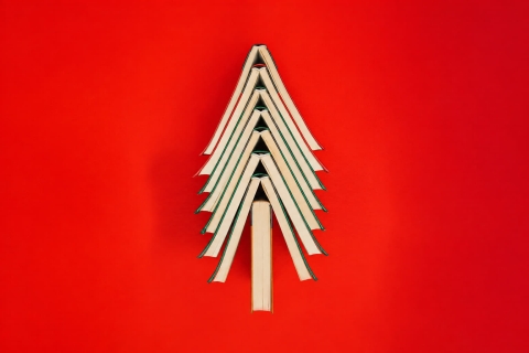 Bücher zu einem Tannenbaum aufeinander gestapelt