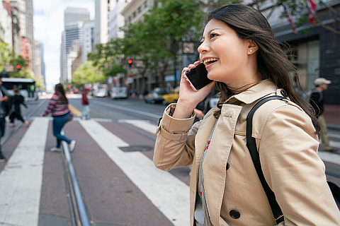 Eine Frau geht in der Stadt und telefoniert dabei mit