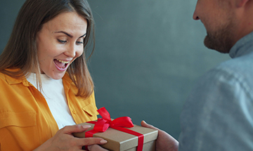 Mann übergibt ein Geschenk an junge Frau